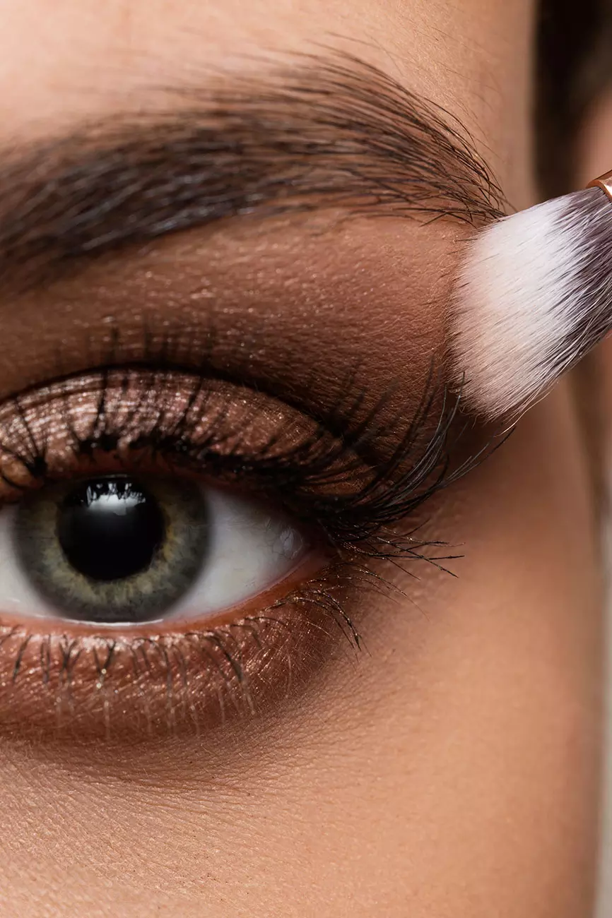Dettaglio ravvicinato di un occhio con ciglia ben definite e trucco elegante, evidenziando la texture della pelle e l'applicazione del make-up.